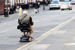 Man on mobility scooter driving on road