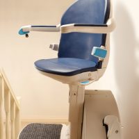 Handicare 1000 stairlift in blue at the top of the stairs