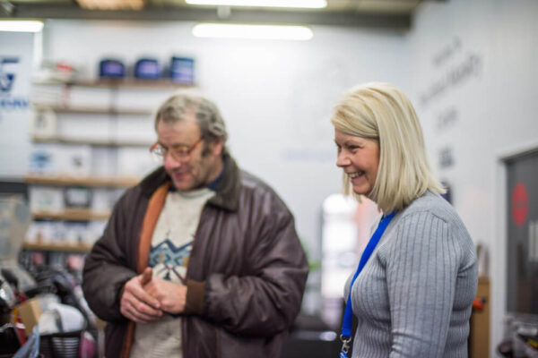 A customer and a member of Ideas in Action's staff looking at products.